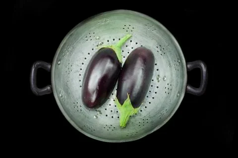 Colander with two eggplants Stock Photos