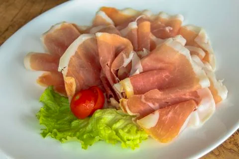 Cold appetizer - Prosciutto (ham). Closeup. Stock Photos