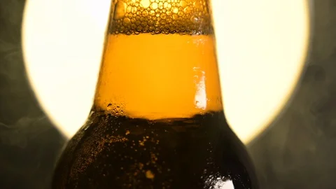 Cold Beer Bottle  Water Drops, smoke fog sun or moon vintage  background Stock Footage 128769965