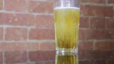 Cold beer from a dark bottle is poured into a large mug Stock Footage 135138153