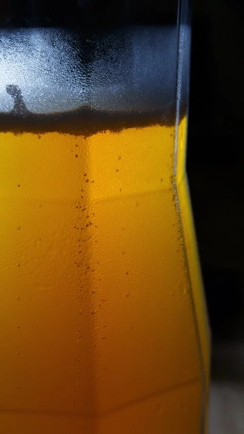 Cold Beer Glass Bubbles Backlit Close-Up Macro Shot Golden Light Stock Footage 340050796