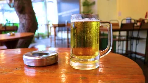 Cold Beer Glass Mug On Bar Table With Ashtray Lifestyle Thailand. Stock Footage 341247205