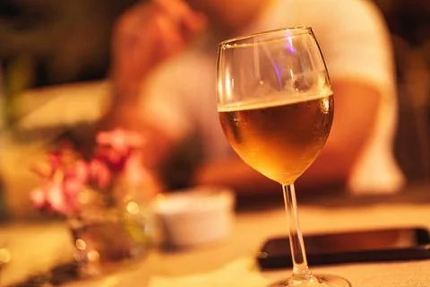 Cold beer glass on table during evening social gathering Stock Photos