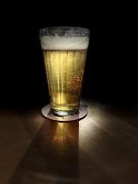 A cold beer glass is on the table. Stock Photos