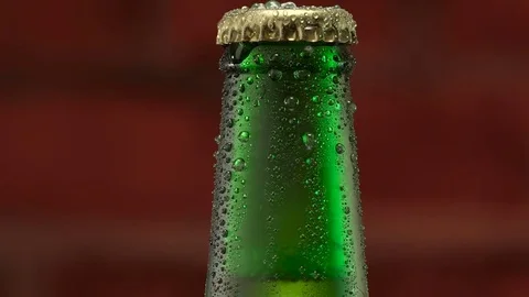 Cold beer in a green bottle with macro water drops Stock Footage 77824228