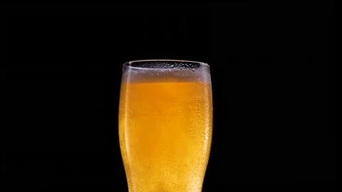 Cold beer isolated on matte black background. Glass of beer with water drops Video stock 153933803
