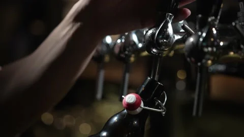 Cold beer is poured into a bottle at the bar Video stock 219651413