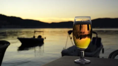 Cold Beer on Table Overlooking Sunset Sea and Boats, Fethiye Stock Footage 324533361