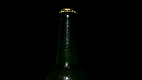 Cold beer with water drops on the bottle is illuminated by light Stock Footage 153274572
