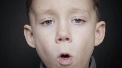 A cold boy close-up on a black background. slow motio Stock Footage 162474176