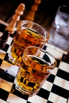 Cold brandy on a chess board, selective focus Foto stock