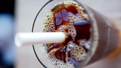 Cold brew coffee and bubble tea in a glass with ice and big white straw close up Stock Footage 247480546