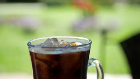 Cold brew coffee and ice cubes - close up shot with green background Stock Footage 151995165