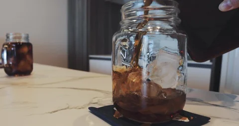 Cold Brew coffee pouring into the jar with an ice Video stock 94368744