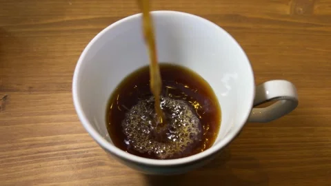 Cold Brew Coffee Pouring into White Mug with Bubbles on Wooden Table Vídeo Stock 347301539