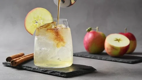 Cold brew coffee pours over iced apple cider tonic, creating layered refreshing Stock Footage 345557085