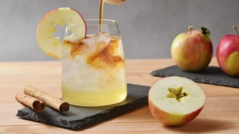 Cold brew coffee pours over apple cider tonic and ice, creating layered drink Stock Footage 345558112