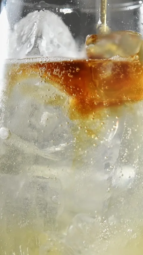 Cold brew coffee spreads over sparkling apple cider and tonic with ice in Stock Footage 345487217