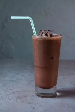 Cold Chocolata serving in glass with straw side view on background Stock Photos