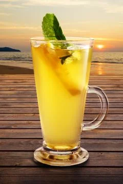 Cold citrus tea on the table with sunset view on background Foto stock