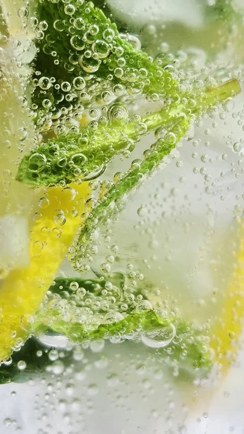 Cold Cocktail with lemon and mint close-up in a glass. Fresh lemonade Stock Footage 310447304