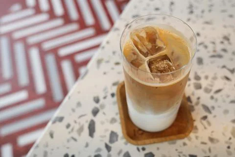 Cold coffee drink sits on table with patterned surface Stock Photos
