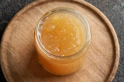 Cold congealed beef bone broth in a glass jar on a table Foto stock