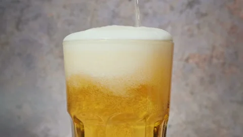 Cold craft  light Beer is pouring from bottle on wooden Table Stock Footage 194307383