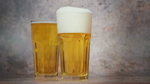 Cold craft  light Beer is pouring from bottle on wooden Table Vídeos de archivo 194307709