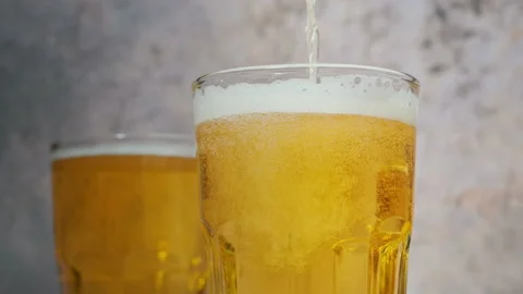 Cold craft  light Beer is pouring from bottle on wooden Table 库存影片 194307801
