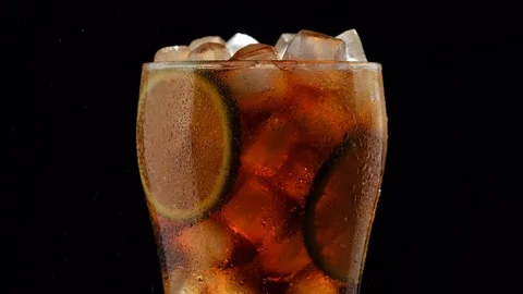 Cold Cuba libre cocktail or Cola drink with Ice cubes, bubbles, sliced lime Stock Footage 121874098