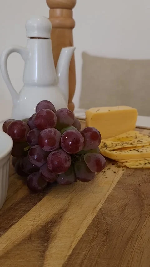Cold cuts board with grapes cheese and seasoning on dining table Stock Footage 201546915