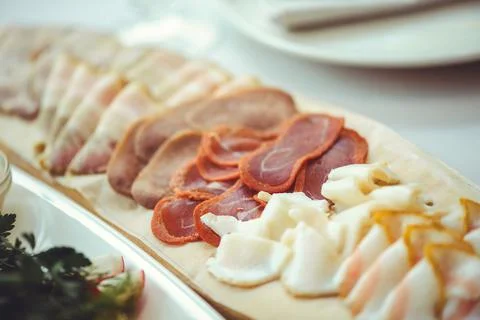 Cold cuts with ham, bacon, salami and bacon on a light background. Meat platt Stock Photos