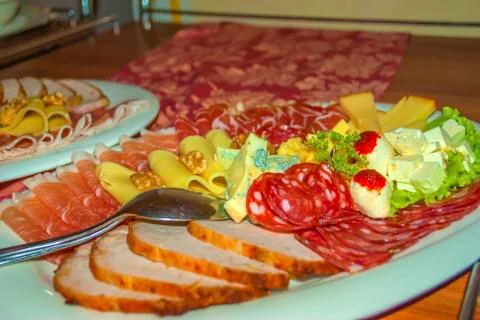 Cold cuts plate with salami, prsuto. cheese with nuts on green salad Stock Photos