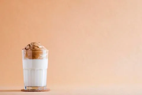 Cold dalgon coffee in clear glasses on a dark wooden background. foam from su Foto stock