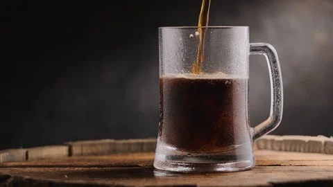Cold dark beer in a beer mug on a dark background. Stock Footage 125638080