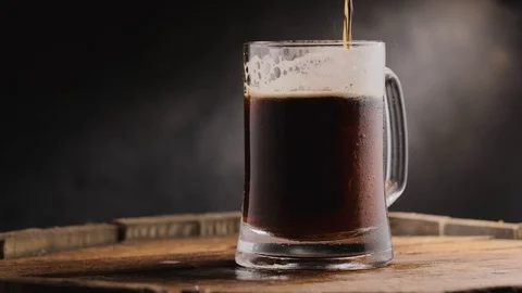Cold dark beer in a beer mug on a dark background. Stock Footage 125638338