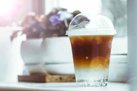 A cold, double-layer espresso tonic sits on a windowsill in a coffee shop. Stock Photos