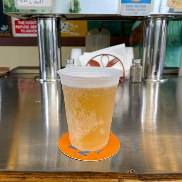 A cold draft beer in a glass sitting on a bar in Florida. Stock Photos