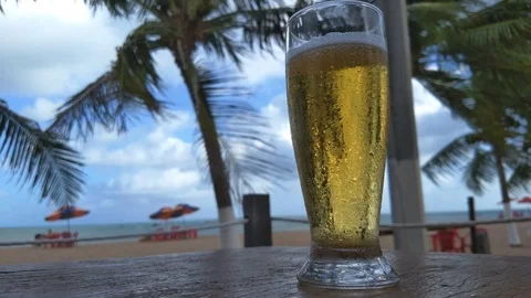 Cold draft beer sweating on the beach paradise loop in Brazil HDR Stock Footage 100346125