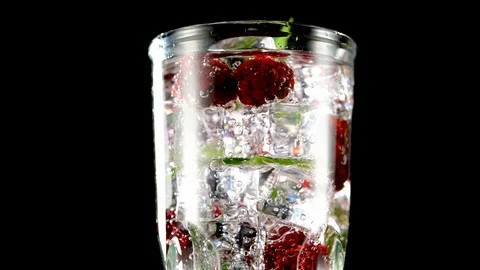 Cold drink with blackberries and mint on a black background closeup Video stock 91893340
