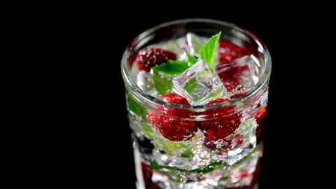 Cold drink with blackberries and mint on a black background closeup Stock Footage 91893376