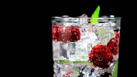 Cold drink with blackberries and mint on a black background closeup Video stock 91893471