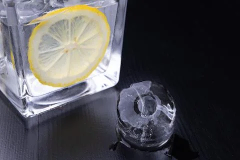 Cold drink in a glass on the kitchen table. Lemon and ice with water the best Stock Photos