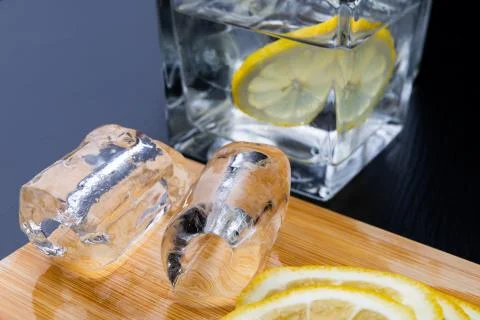 Cold drink in a glass on the kitchen table. Lemon and ice with water the best Stock Photos
