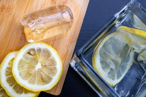 Cold drink in a glass on the kitchen table. Lemon and ice with water the best Stock Photos