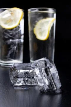 Cold drink in a glass on the kitchen table. Lemon and ice with water the best Stock Photos