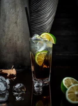 Cold drink with ice cubes and lime slices in dark background Stock Photos