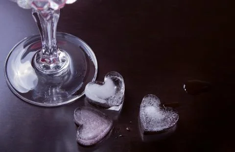 Cold drink with ice in a heart shape on the black background Stock Photos