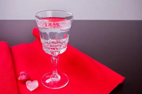 Cold drink with ice in a heart shape on the black background Stock Photos